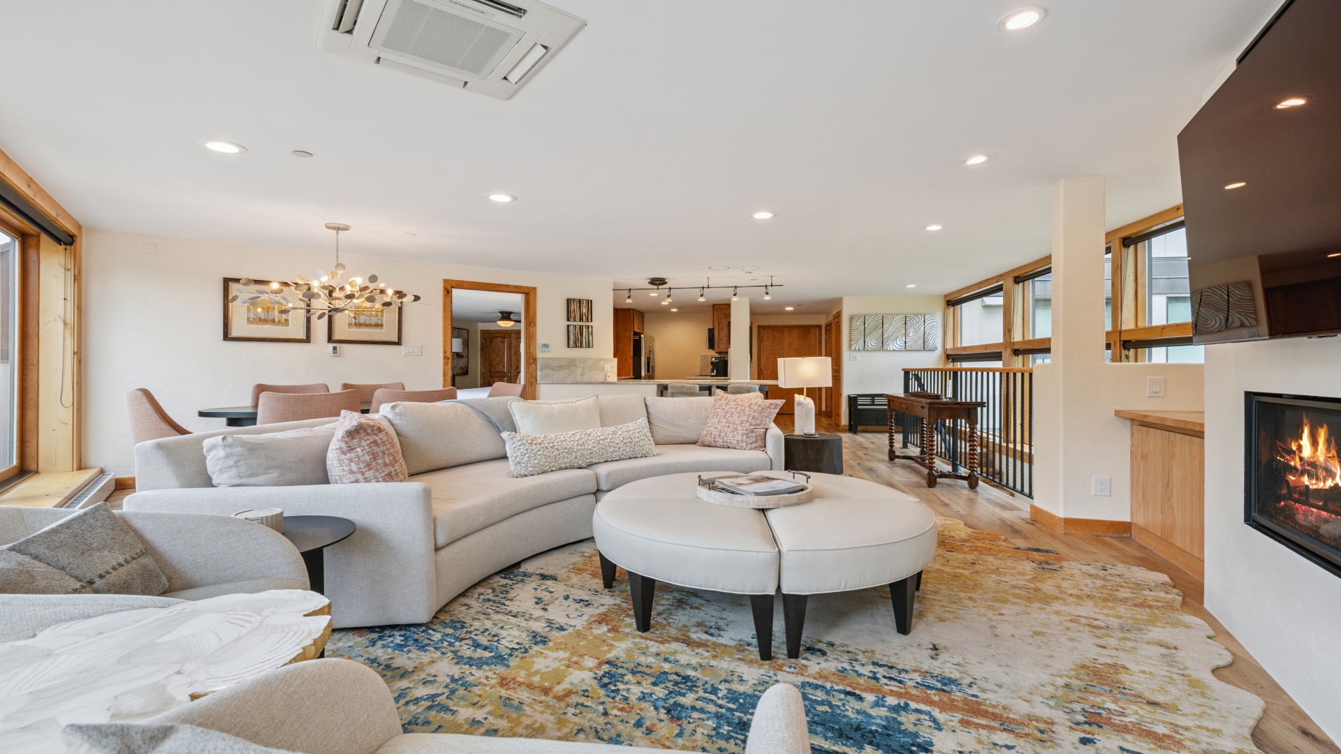 Picture yourself unwinding on plush sofas by the warm fireplace, with ample space to gather, dine, and create memories in this beautifully designed open-concept living area.