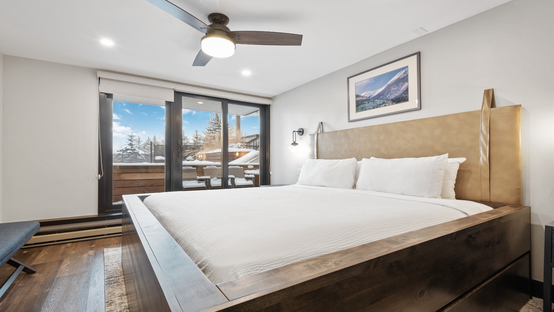Drift off in your bright, modern bedroom with crisp linens and mountain views framed perfectly through your private balcony doors—your alpine retreat awaits.