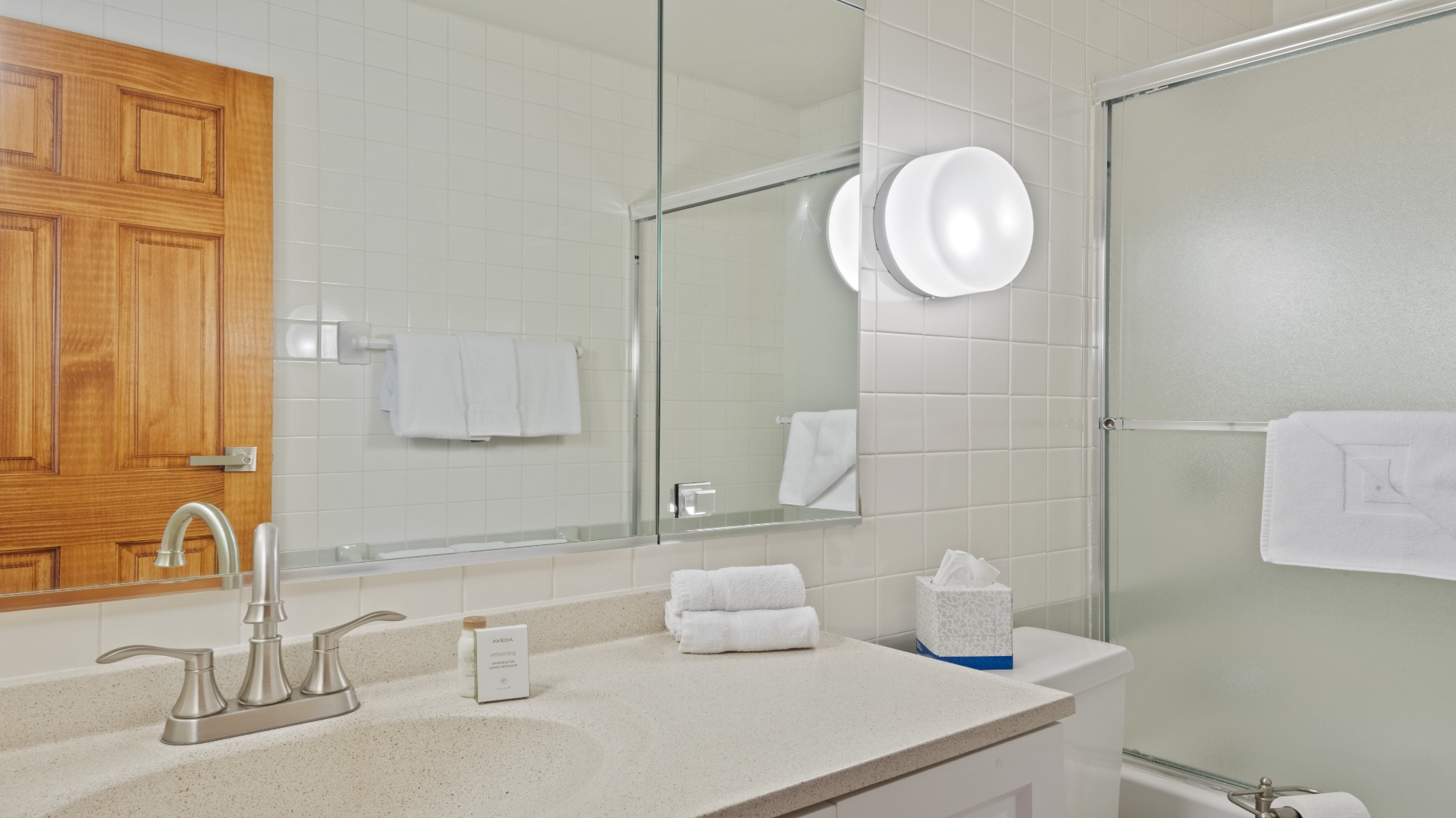 Step into your bright, spotless bathroom with fresh towels waiting, a sleek glass shower, and everything you need to refresh after a day of adventure.