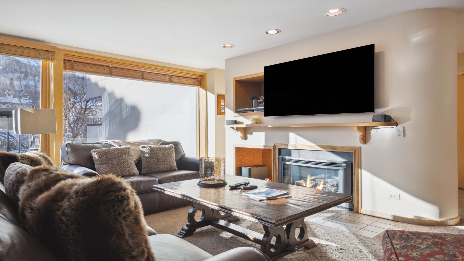 Settle into plush seating by your private fireplace, perfect for cozy mountain evenings. Sunshine pours through large windows, while modern entertainment and thoughtful details create your ideal alpine retreat.