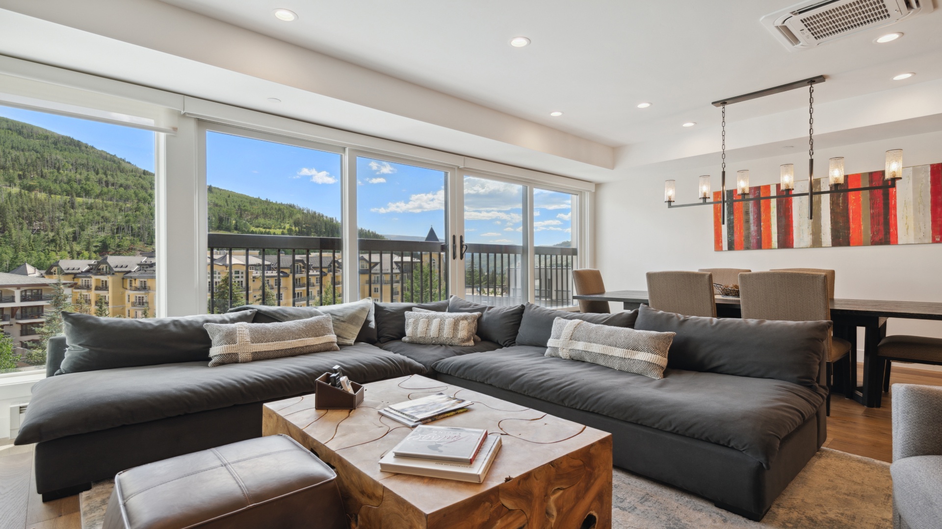 Unwind on plush seating with mountain vistas stretching endlessly before you—a bright, airy retreat where natural beauty meets modern comfort.