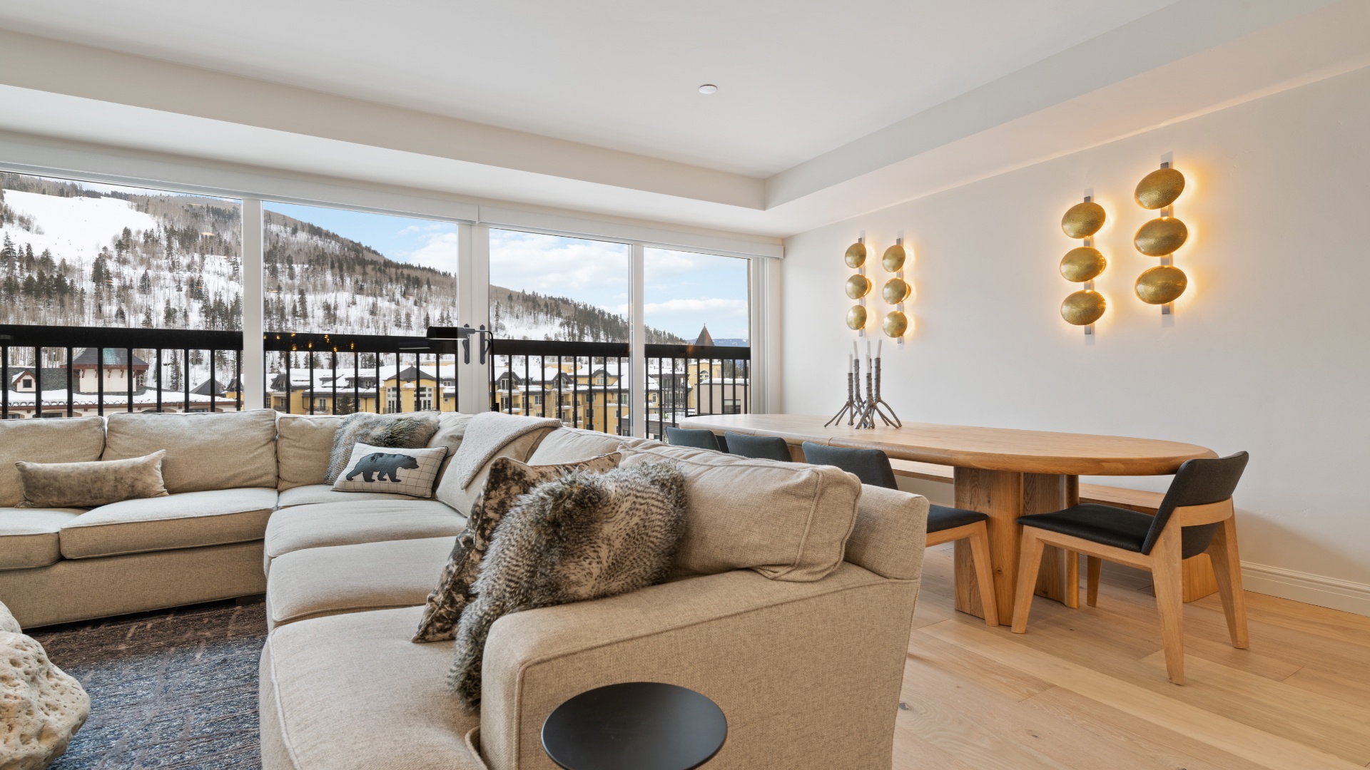 Unwind on plush seating with snow-capped mountain views framing your alpine escape. Modern elegance meets cozy comfort in your mountain retreat.