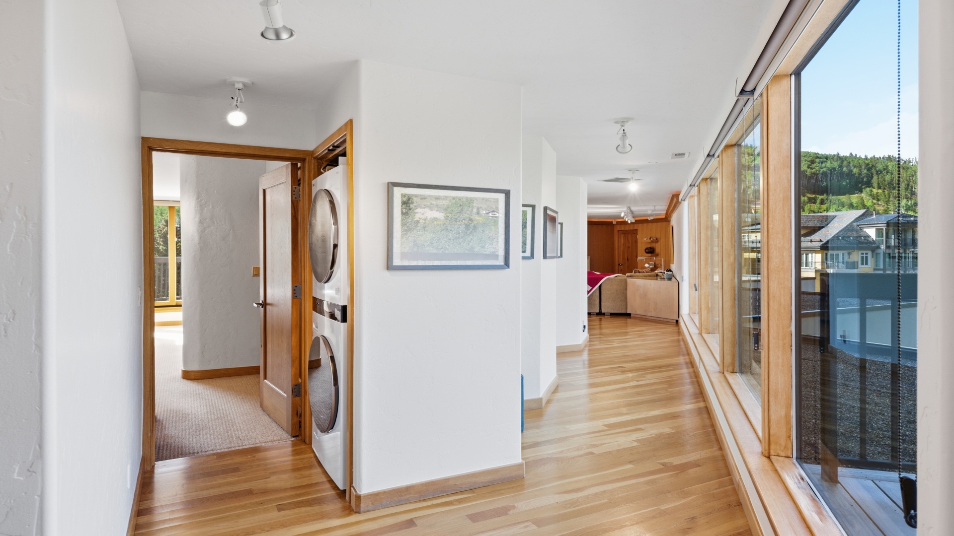 Light floods through floor-to-ceiling windows, inviting you to step inside your peaceful retreat where warm wood tones and mountain views create a welcoming atmosphere.