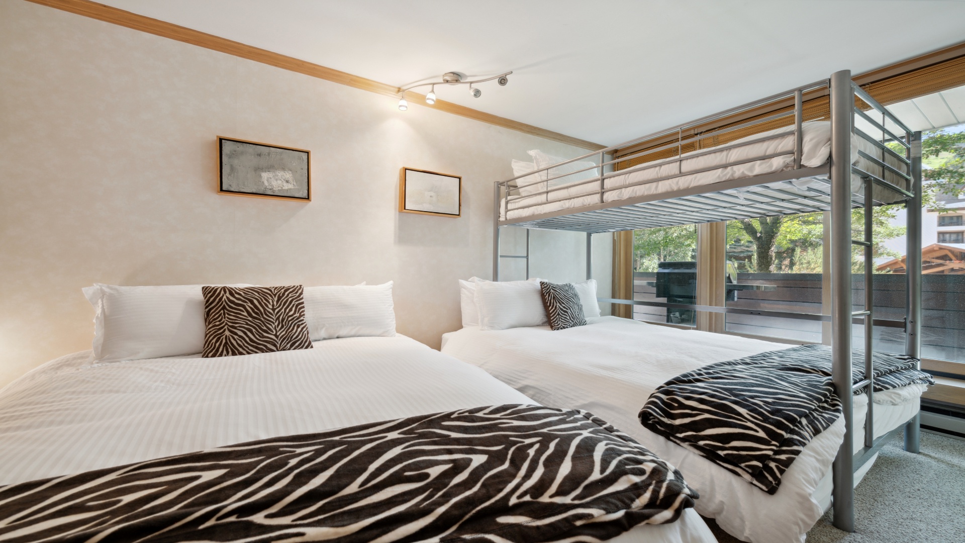 Your bright, spacious bedroom features crisp white linens and modern bunk bed, perfect for families. Natural light streams through large windows, creating a warm, welcoming atmosphere.