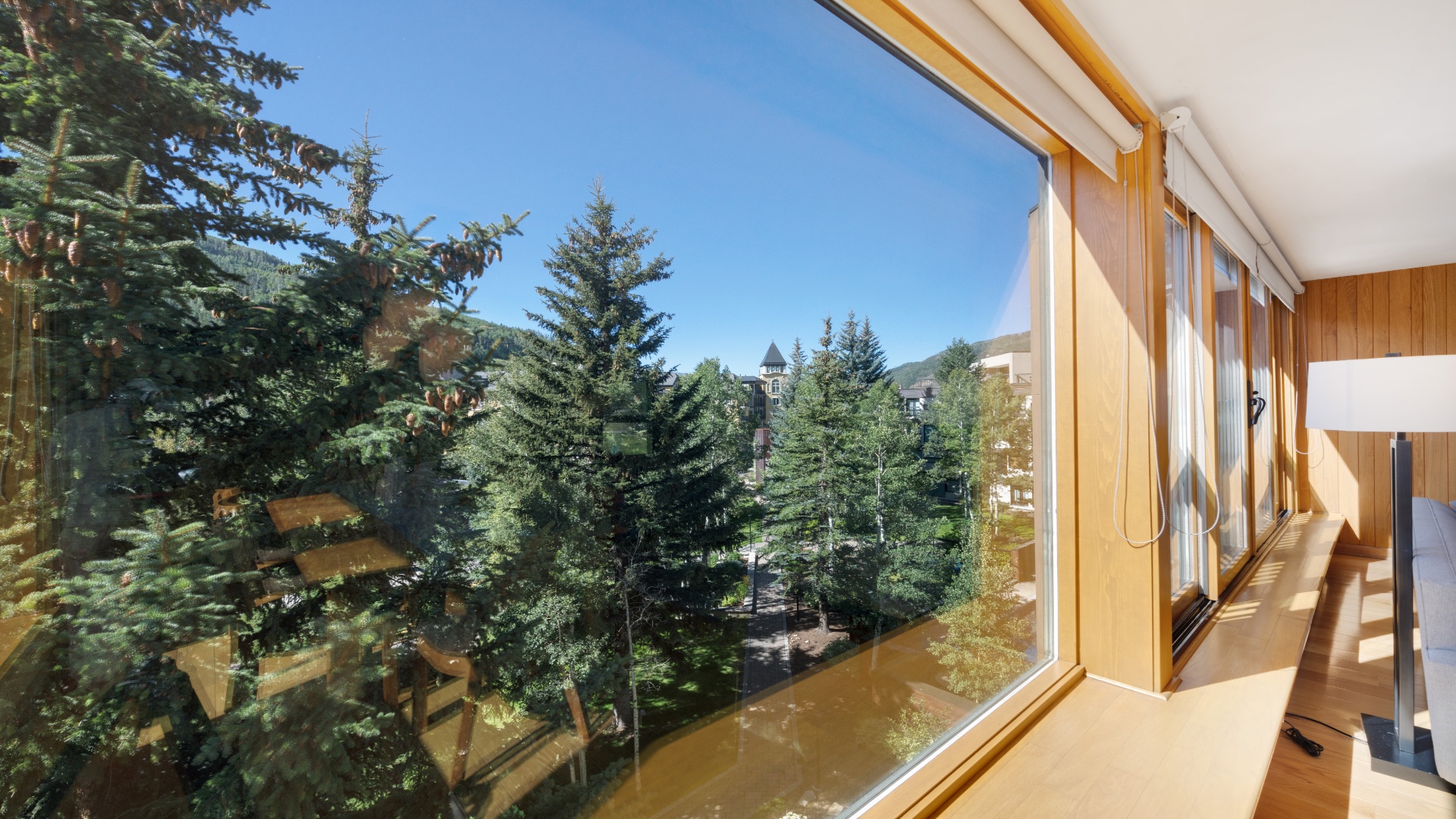 Stunning alpine views frame evergreen forests and distant landmarks from this sun-filled mountain retreat, where natural light and peaceful surroundings create your perfect escape.