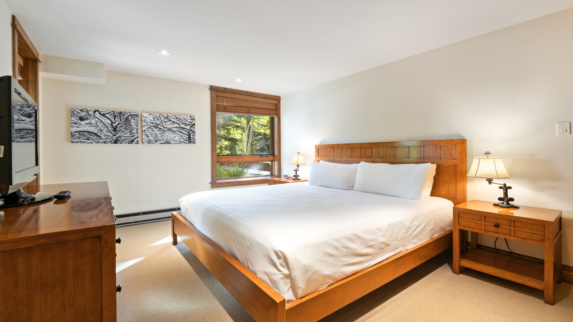 Sink into crisp linens and wake to forest views in your peaceful bedroom retreat, complete with warm wood furnishings and soft lighting.