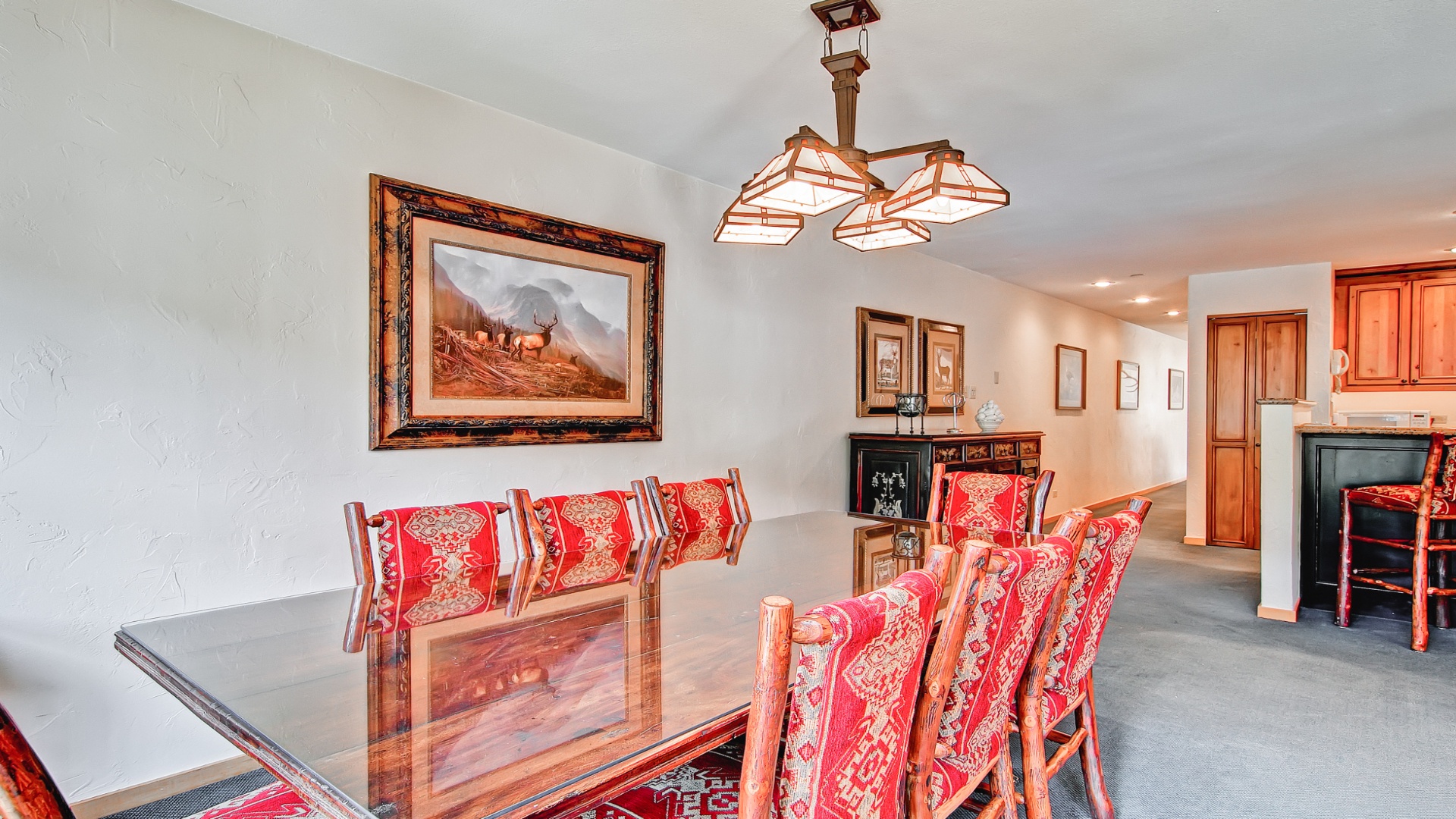 Gather around the elegant dining table under warm ambient lighting, perfect for memorable meals with loved ones in your mountain getaway.