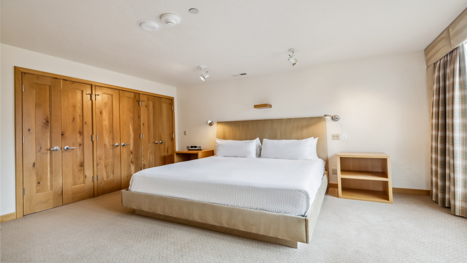 Sink into crisp linens and rest easy in this serene bedroom. The plush bed invites peaceful sleep, while ample storage and thoughtful lighting create a calm retreat for your stay.
