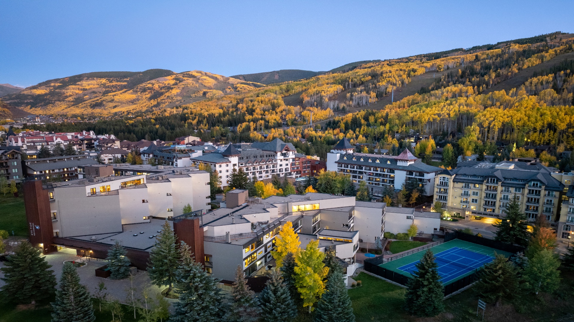 An alpine resort town nestled beneath golden autumn hillsides, offering access to mountain recreation, tennis courts, and scenic landscapes.