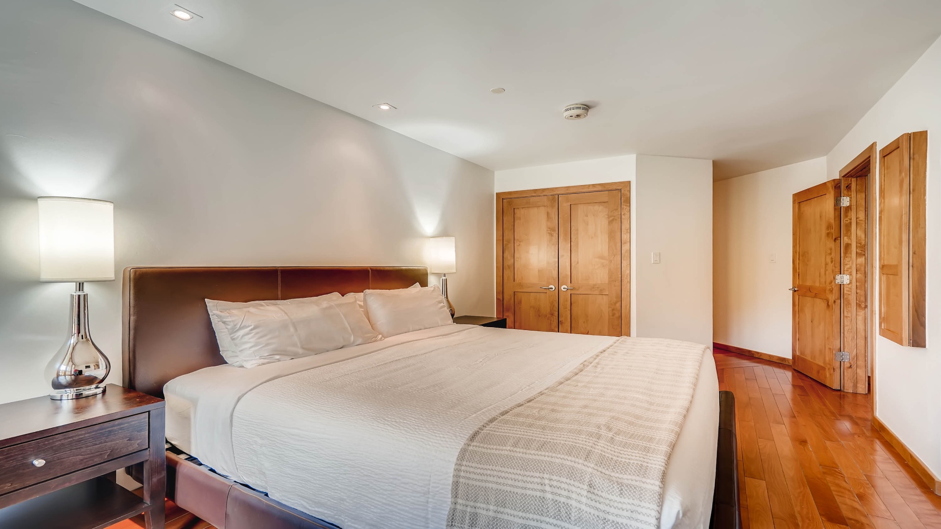 Sink into your private sanctuary after a day of exploring. Soft lighting and crisp linens create the perfect retreat for restful nights in this spacious bedroom.