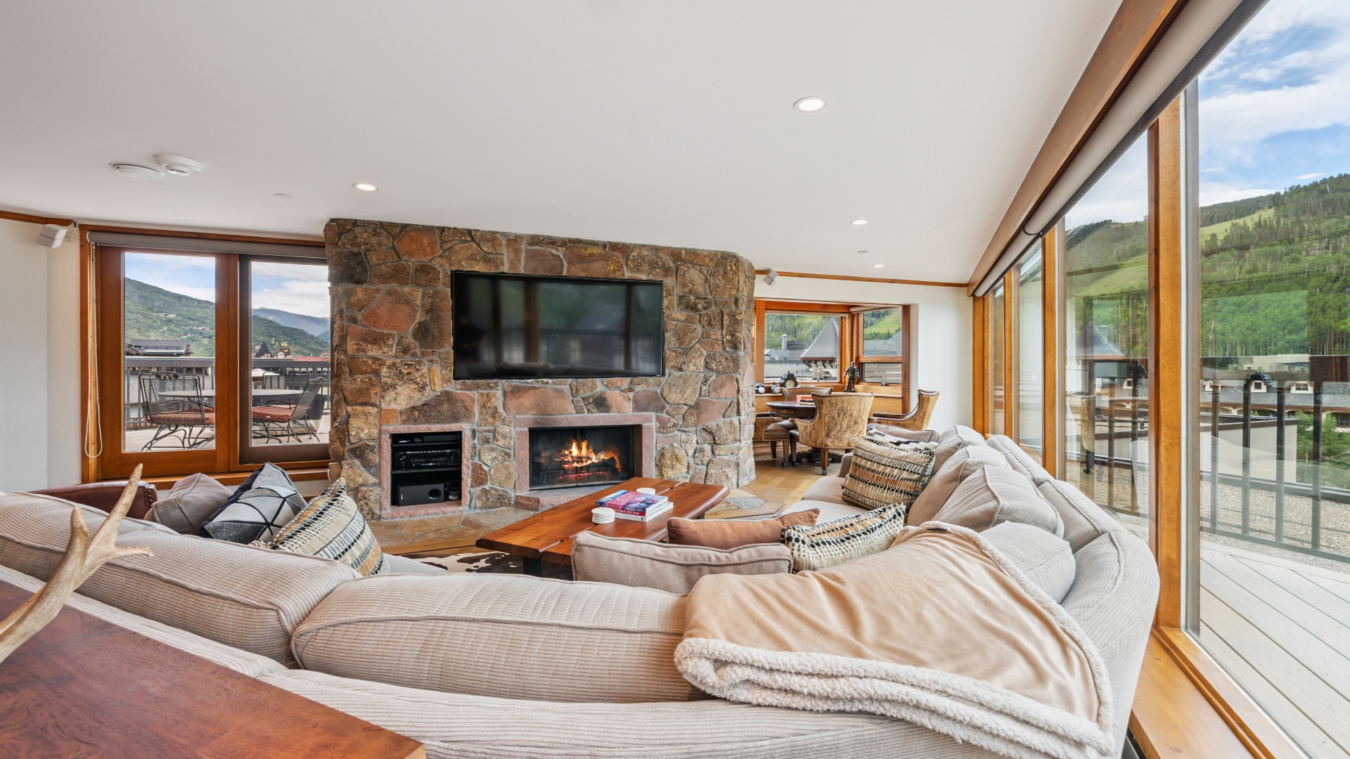 Curl up in your spacious living area with a glowing fireplace, stunning mountain views, and plush seating perfect for relaxing after a day of adventure.