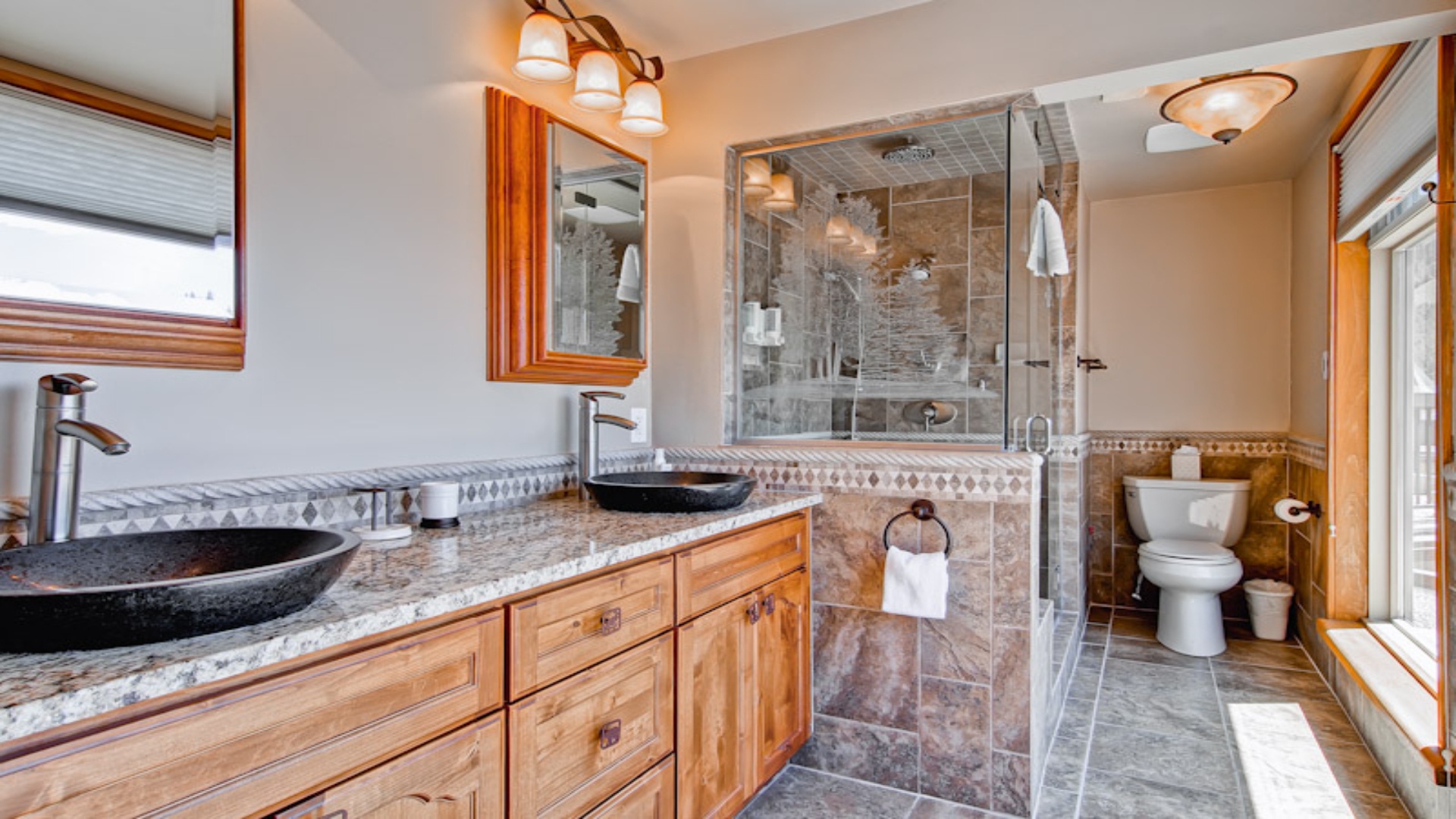 Step into your spa-inspired bathroom where dual vessel sinks and a luxurious walk-in shower with elegant tile work await your daily refresh.