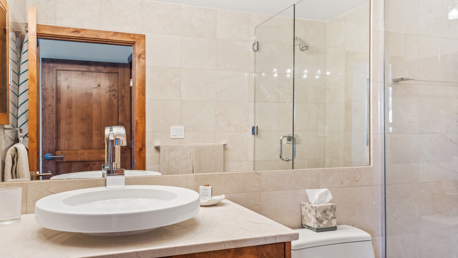 Step into your private spa-like bathroom with elegant stone surfaces, a spacious glass-enclosed shower, and modern fixtures that create a serene retreat for unwinding after your adventures.