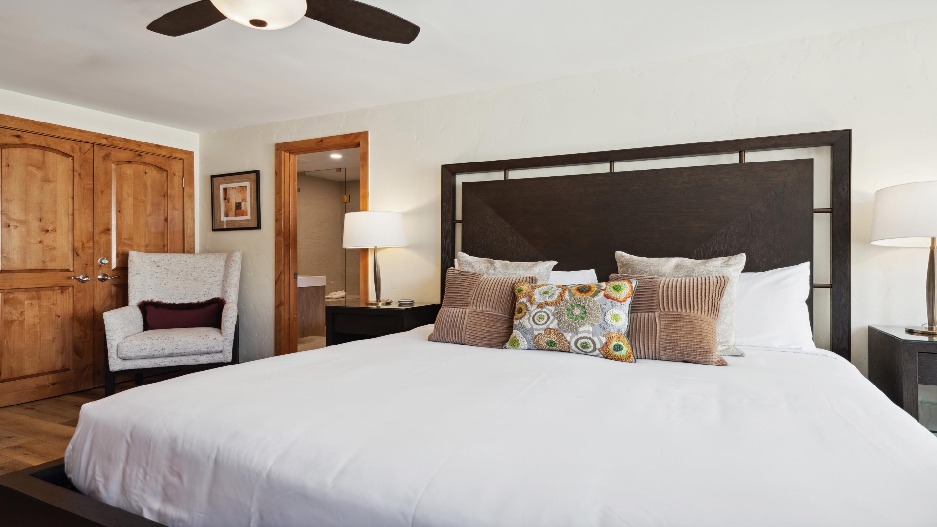 Sink into crisp white linens and let the ceiling fan keep you cool. Warm wood accents and a cozy reading nook make this your perfect retreat after a day of exploring.