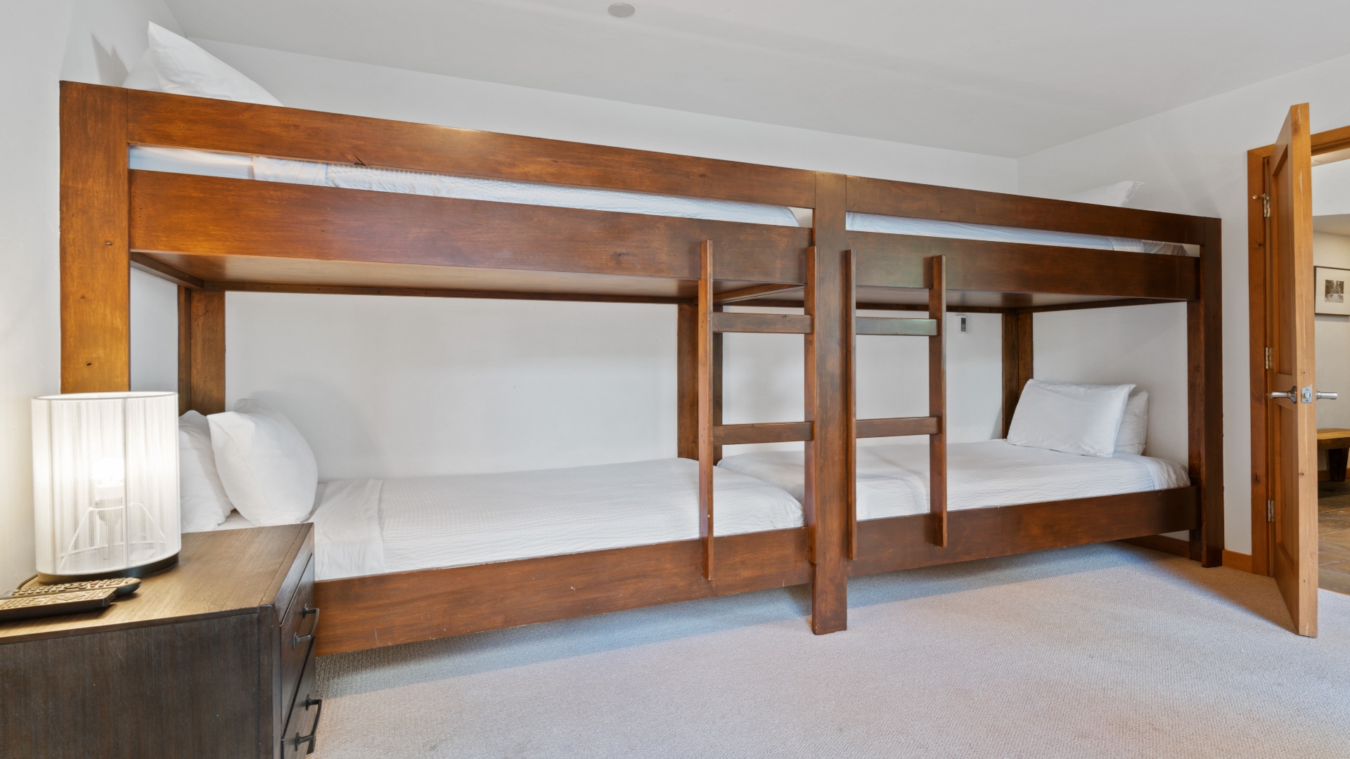 Gather your group in this spacious room featuring custom-built wooden bunk beds with crisp white linens, perfect for family getaways or friends traveling together.