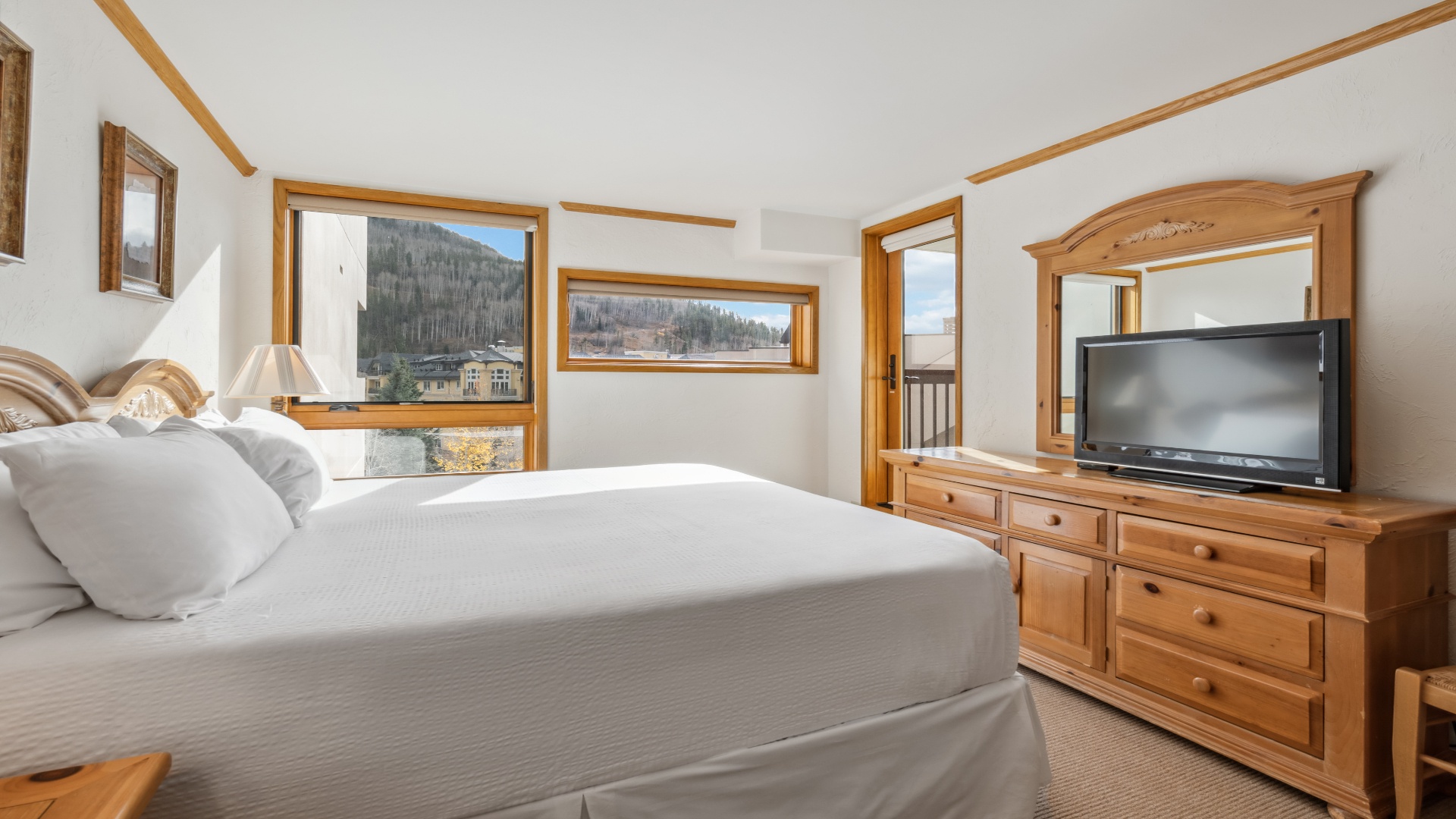 Your cozy mountain bedroom features crisp linens, warm pine furnishings, and stunning ski slope views right from your window—perfect for unwinding after a day outdoors.