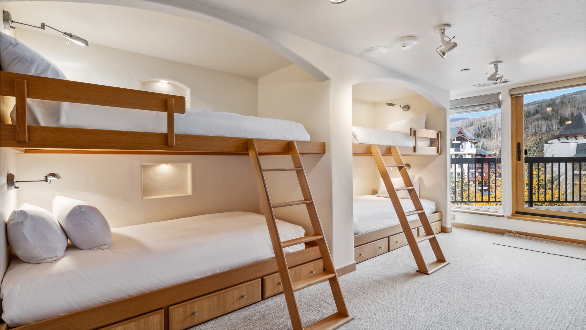 Cozy bunk beds with soft linens and thoughtful lighting create a warm, restful retreat, while your private balcony frames stunning mountain views perfect for morning coffee or evening relaxation.