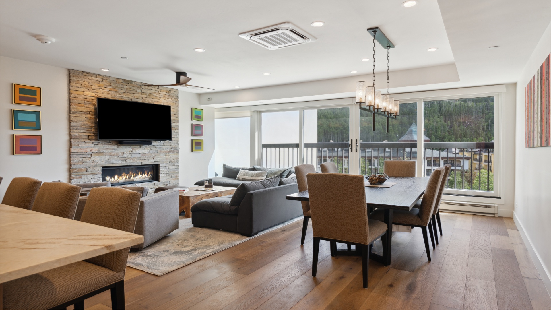 Gather around the inviting fireplace or enjoy meals at the spacious dining table while taking in views of the surrounding mountains through expansive windows.