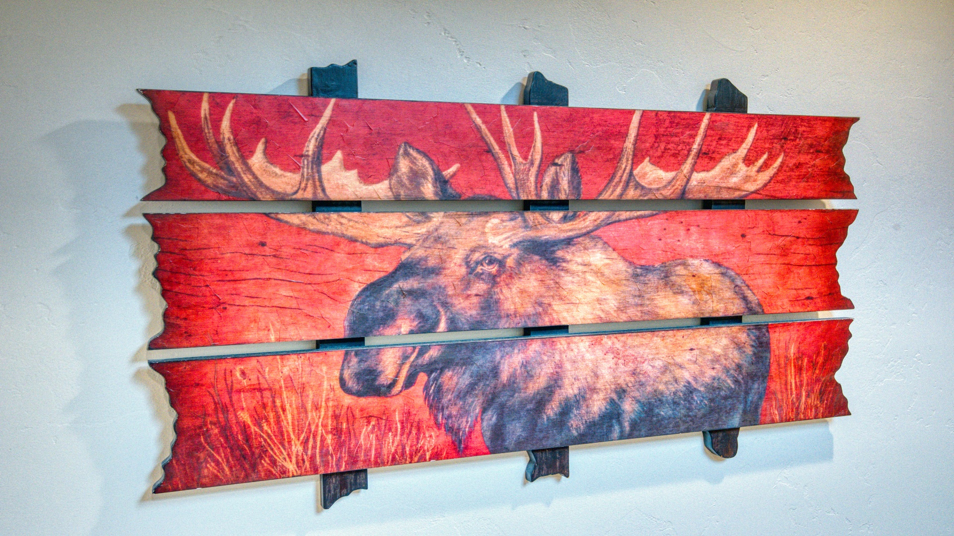A striking moose artwork adds rustic charm to your space, its bold colors and natural imagery creating a cozy, cabin-inspired atmosphere you'll love coming home to.