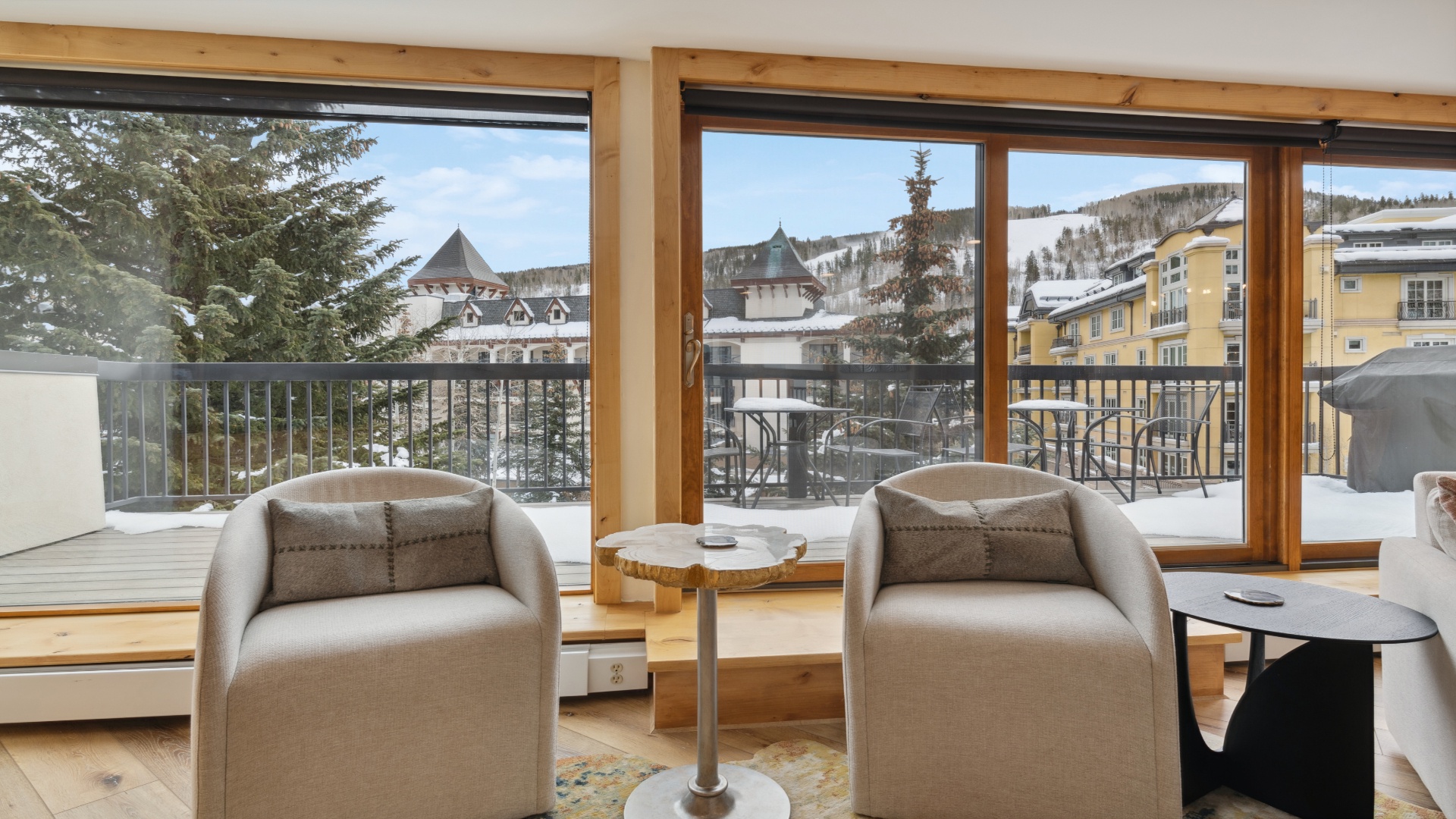 Relax in this cozy seating area with stunning mountain and village views. Large windows frame snowy peaks and charming architecture, inviting natural light into your peaceful retreat.