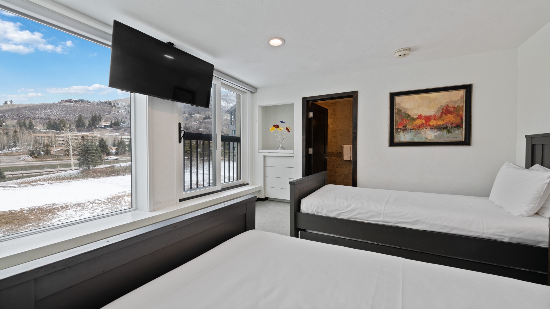 Wake up to mountain vistas from your cozy bedroom, where large windows frame the landscape and modern comfort meets serene natural beauty. Your peaceful retreat awaits.