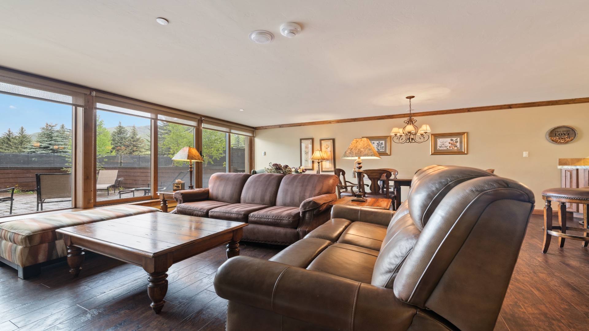 Relax in your spacious living room, where natural light pours through expansive windows and plush leather seating invites you to unwind after a day of adventure.