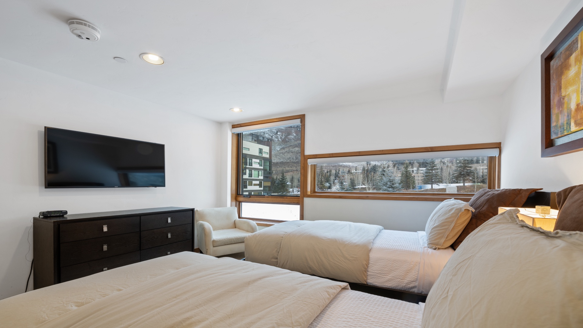 Drift off gazing at snowy mountain views from your twin beds in this light-filled room. The private seating nook and entertainment setup let you unwind in style after alpine adventures.