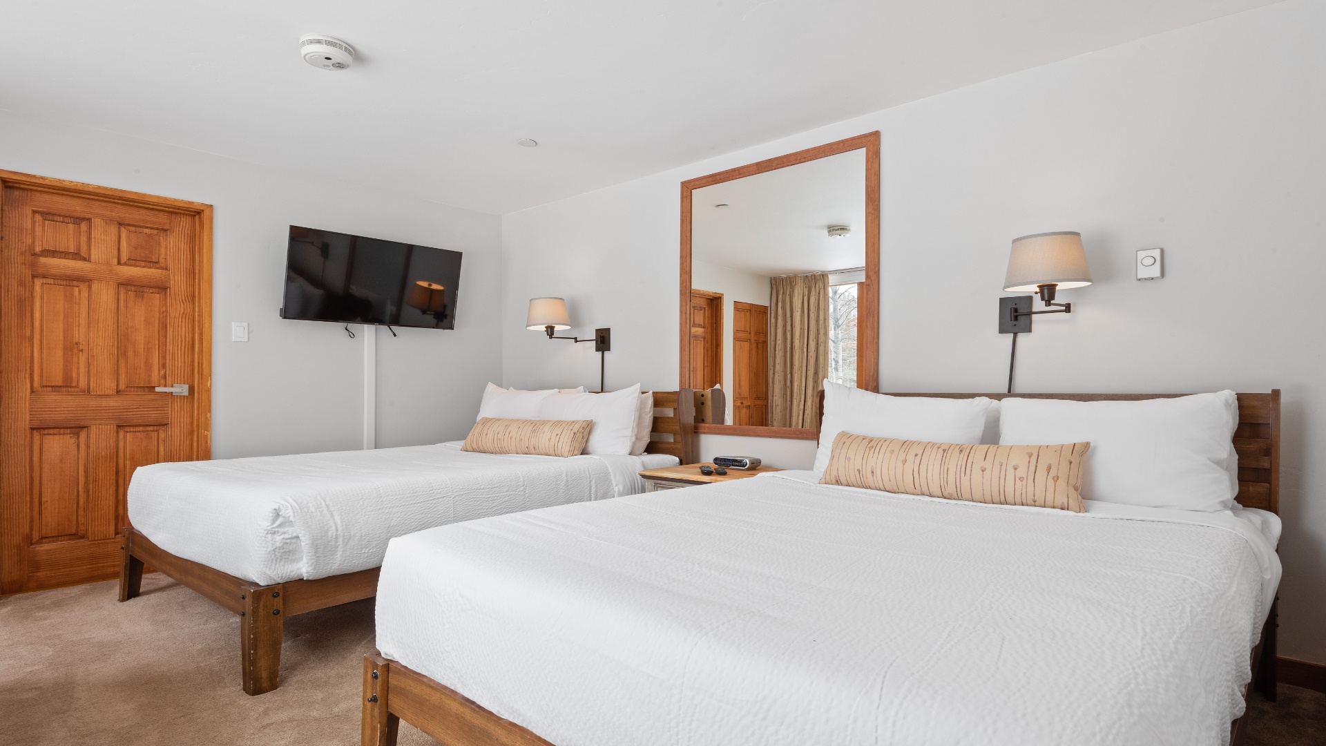 Sink into plush, hotel-style bedding in this serene retreat, where twin beds offer flexible sleeping arrangements and warm wood tones create a welcoming ambiance.