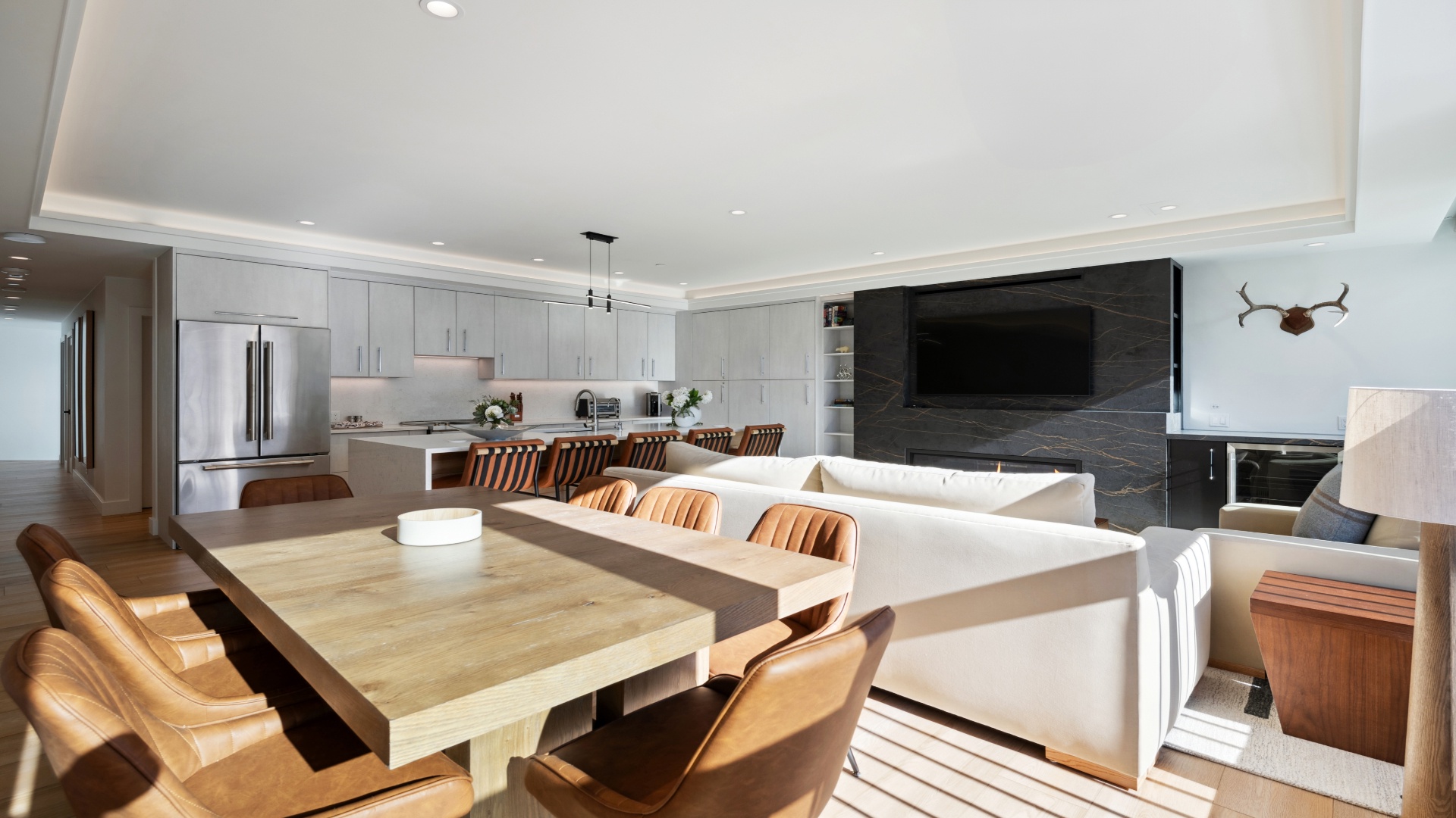 Step into your spacious open-plan haven where sleek modern design meets warm wood accents. Gather around the stunning dining table, unwind on plush seating, and enjoy your favorite shows on the big screen—all in one inviting space.