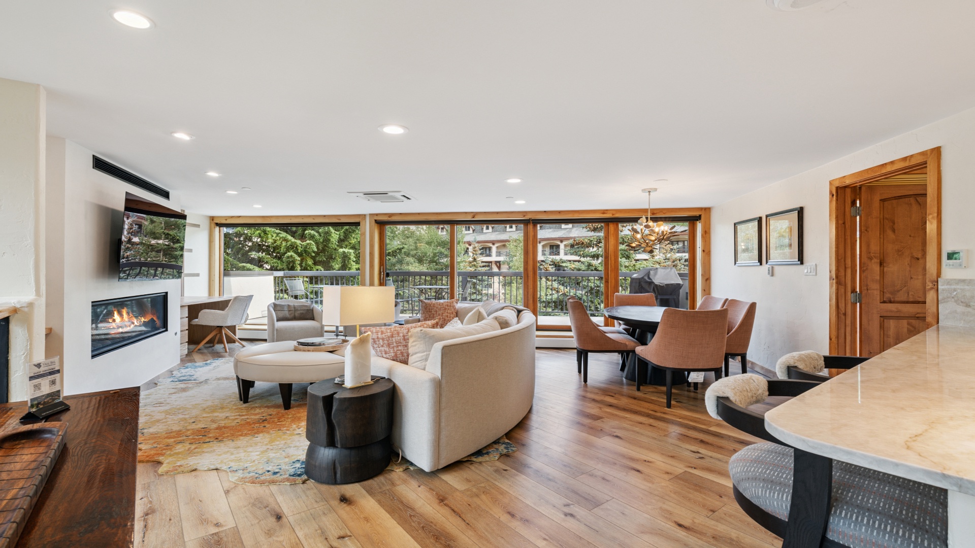 Unwind in this bright, open living space where warm wood floors meet modern comfort. Your living area flows into a cozy dining spot, all framed by stunning windows and a welcoming fireplace.