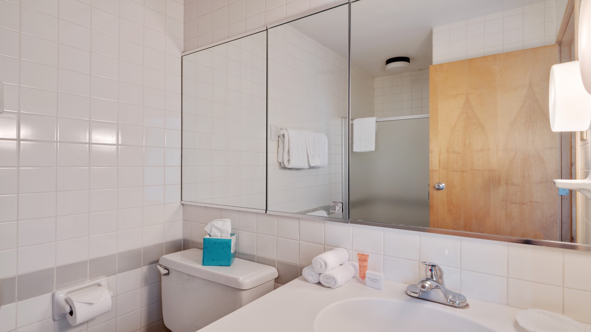 Freshen up in your bright, clean bathroom with crisp white tiles, fresh towels, and everything you need for a comfortable stay.