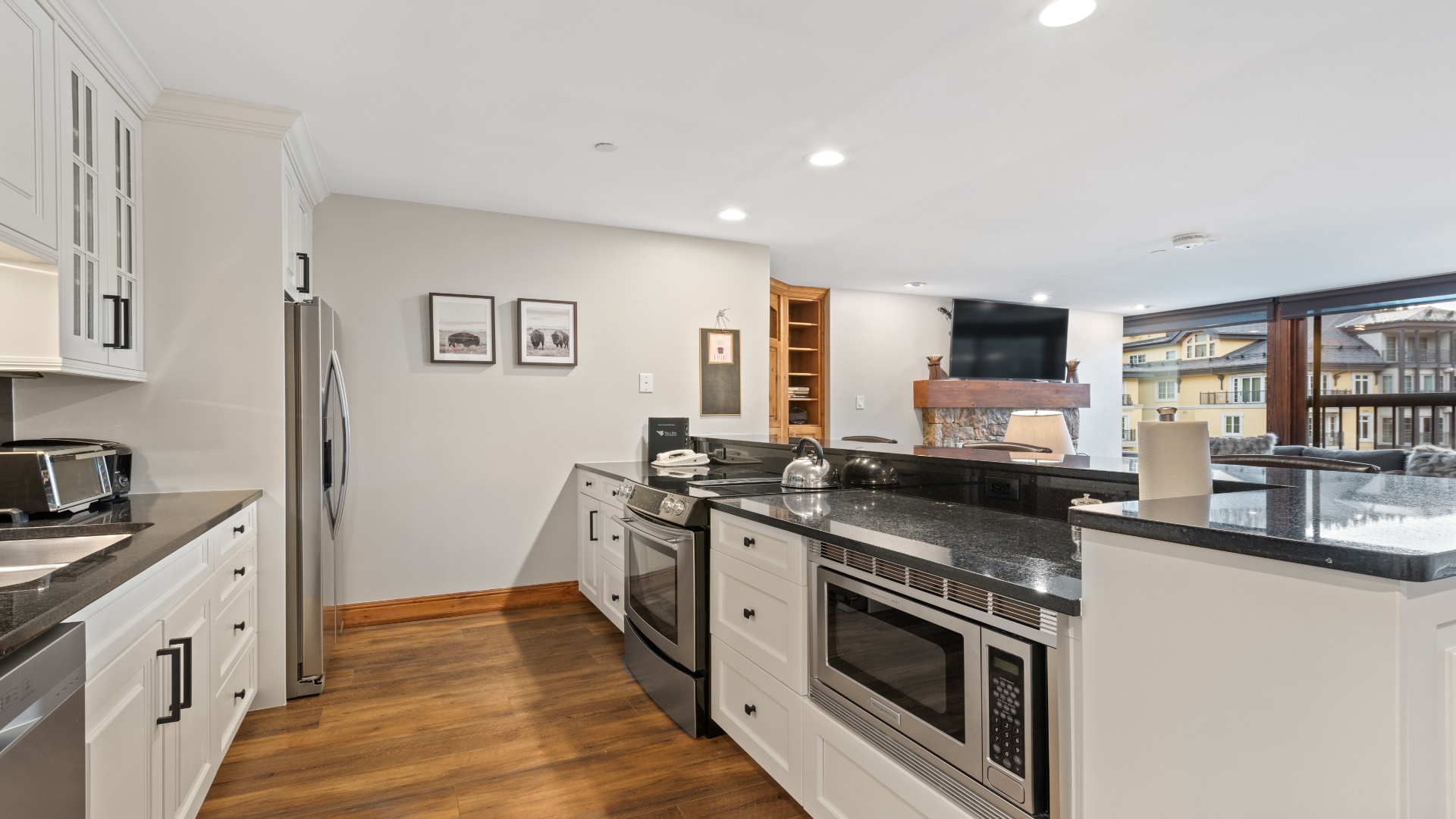 Your fully-equipped kitchen invites you to prepare meals with ease, featuring sleek granite countertops, stainless steel appliances, and charming white cabinetry bathed in natural light.