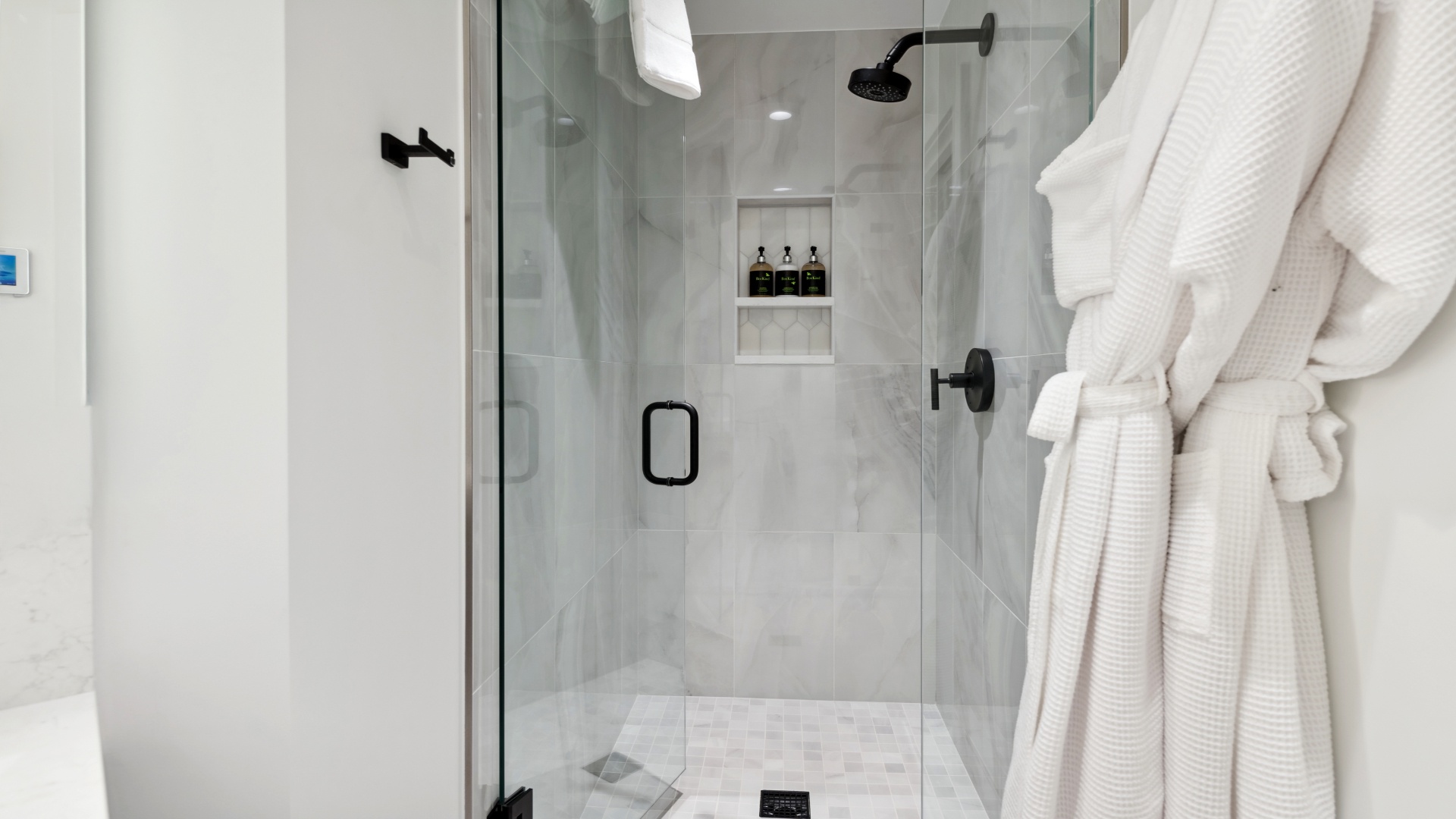 Step into your sleek walk-in shower with elegant marble-style tile, rainfall showerhead, and premium bath amenities ready for your refreshing escape.
