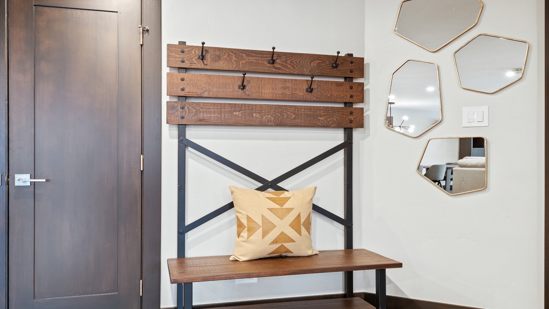 A welcoming entryway features a stylish bench with geometric mirrors, blending function and charm. Hang your coat, drop your bags, and settle in—your mountain retreat awaits.