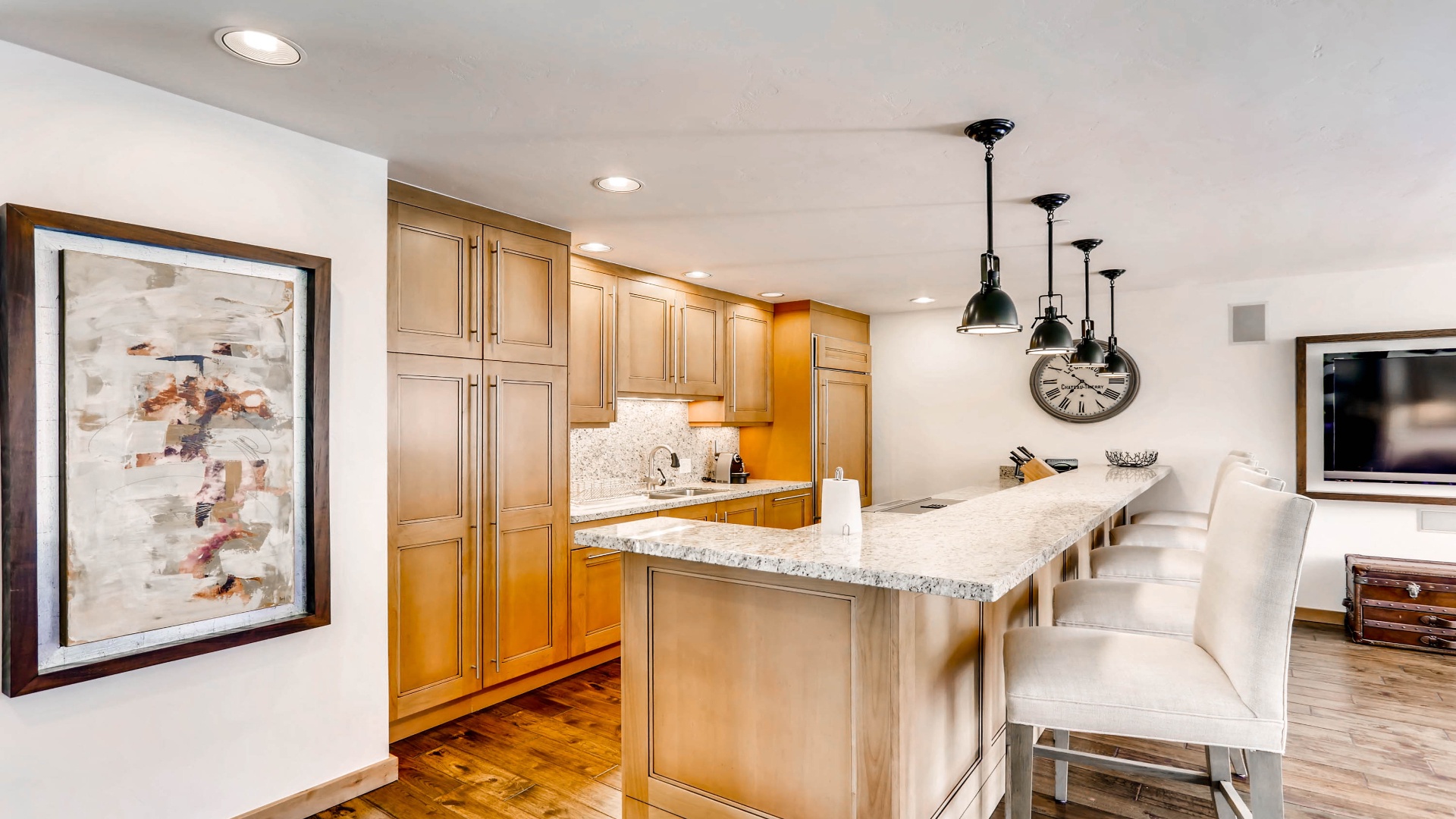 You'll love gathering in this fully-equipped kitchen, featuring gleaming granite countertops, modern pendant lighting, and spacious cabinetry perfect for preparing memorable meals together.