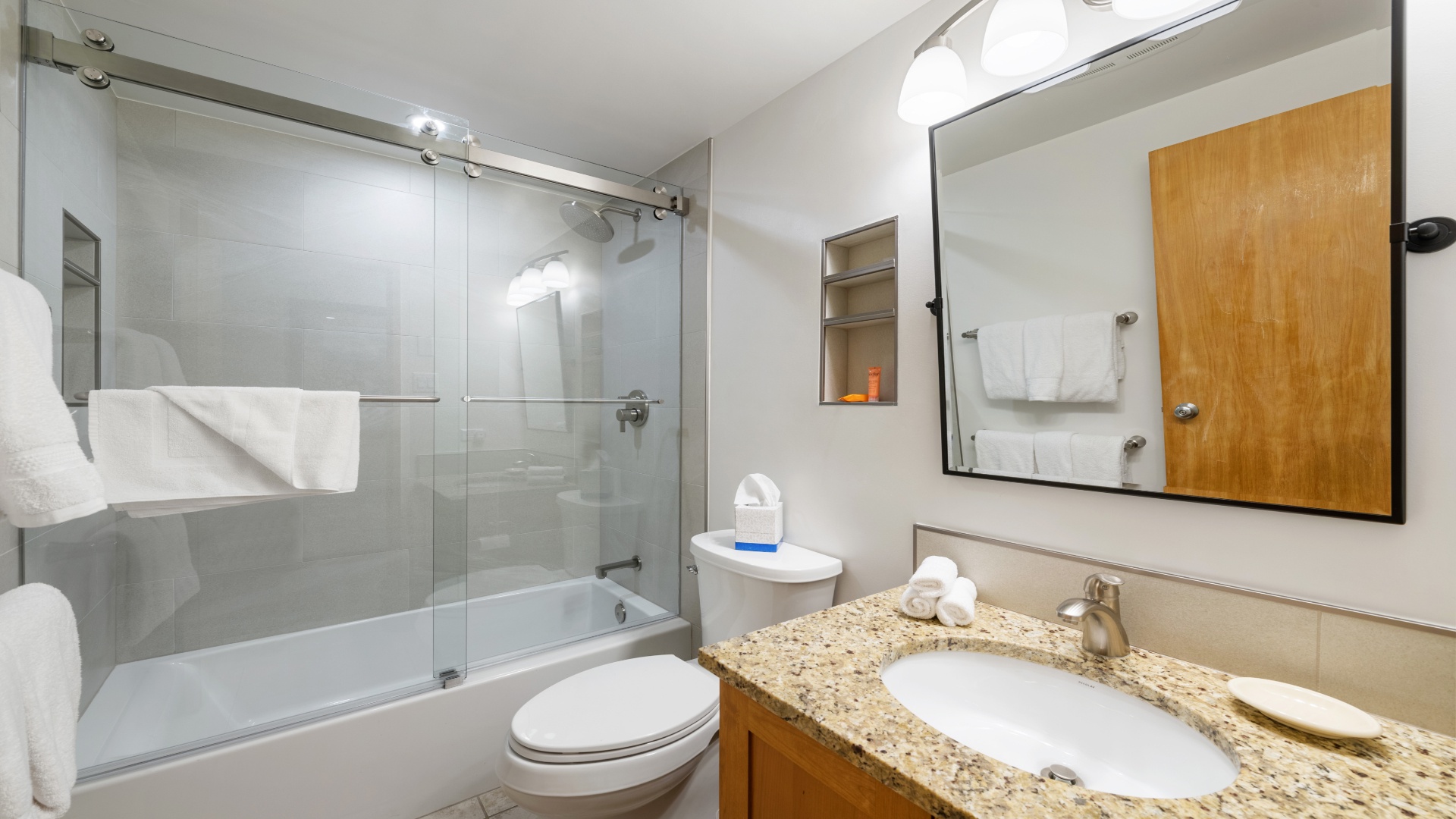 Refresh in your modern bathroom with a spacious tub-shower combo, granite vanity, and fluffy towels—all the comforts you need after a day of exploring.