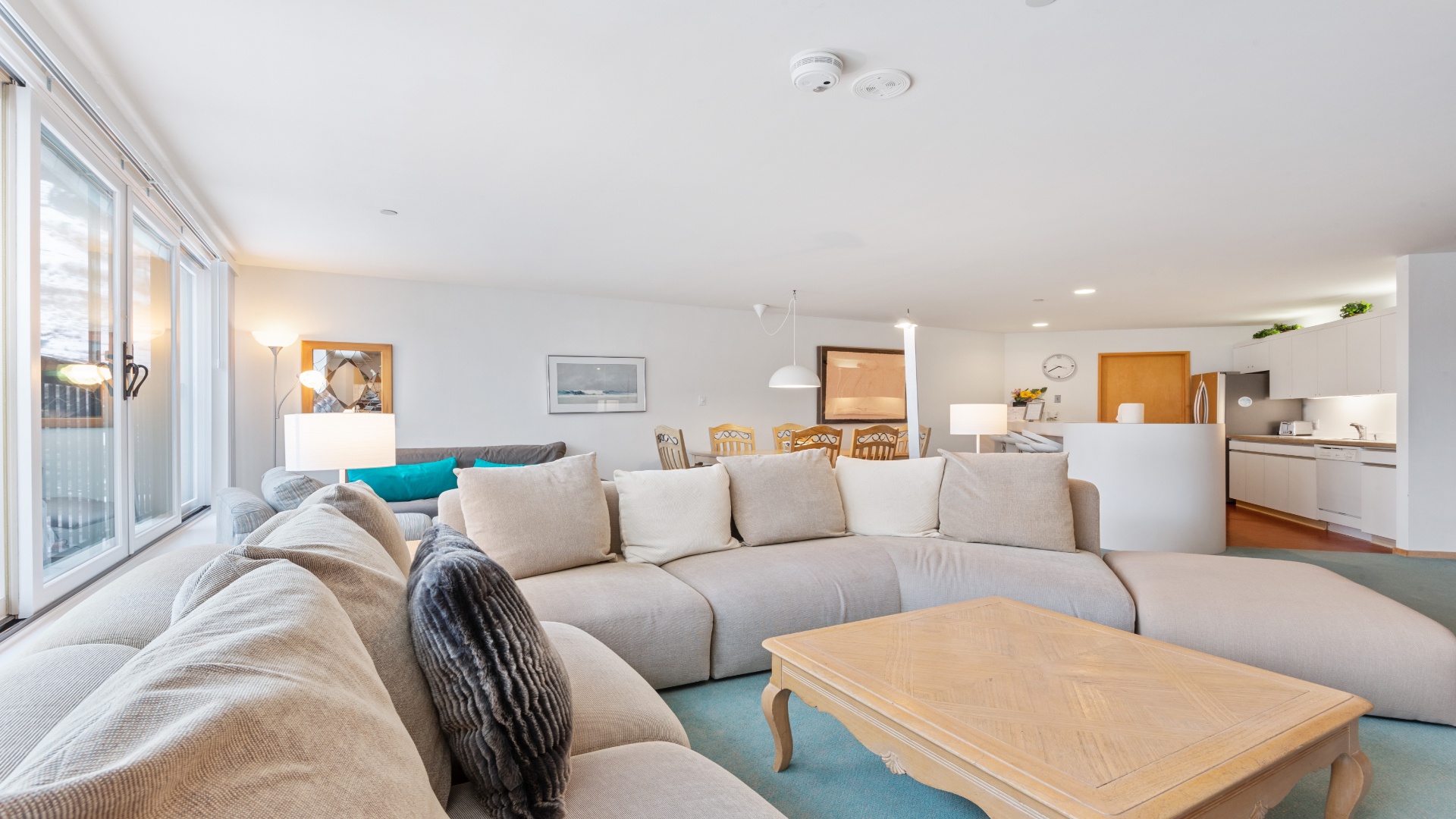 Sink into plush seating where natural light pours through sliding glass doors. This open-concept space flows from lounge to dining to kitchen, creating a warm, airy retreat for your group.