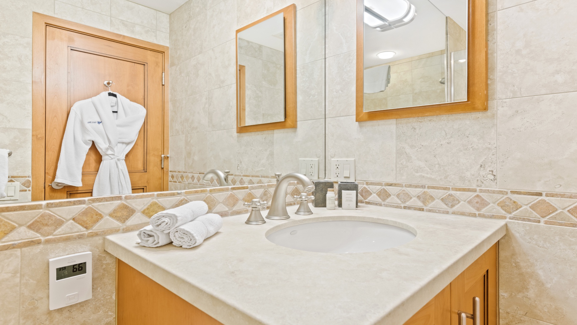 Refresh in your stylish bathroom, featuring warm wood accents, elegant tile work, soft robes, and fluffy towels ready for your stay.