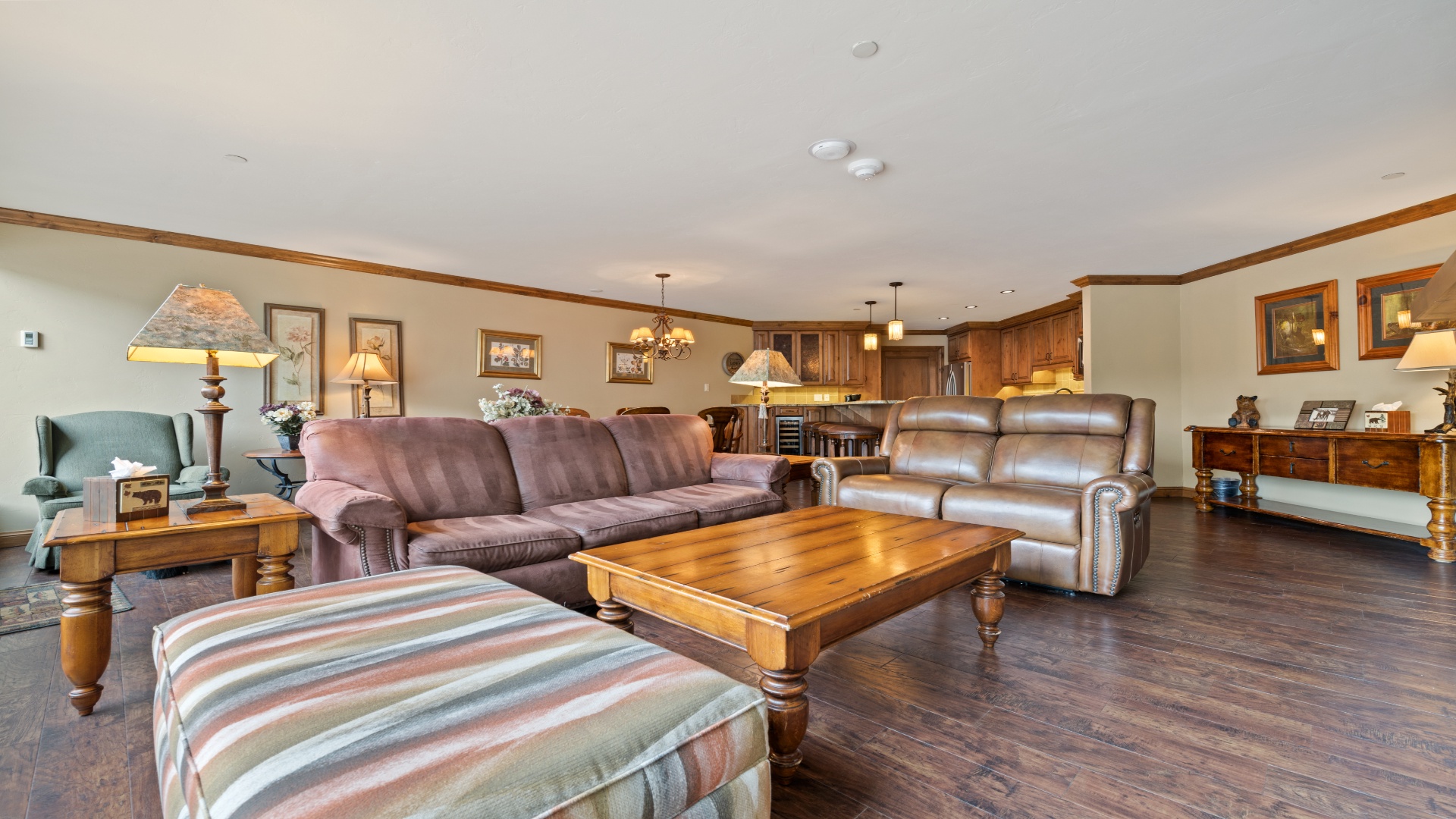Unwind in this spacious open-plan living area, where rich wood floors, plush sofas, and warm lighting invite you to relax and feel truly at home during your stay.