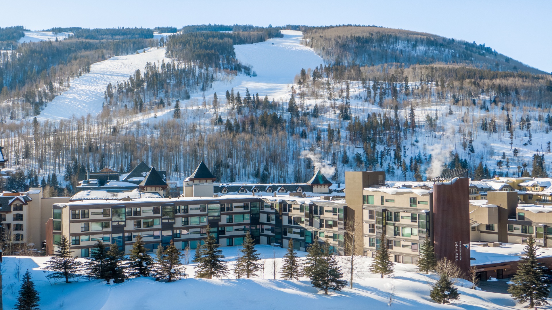 Modern mountain resort property nestled at the base of snow-covered slopes, offering convenient access to world-class winter recreation and stunning alpine scenery.