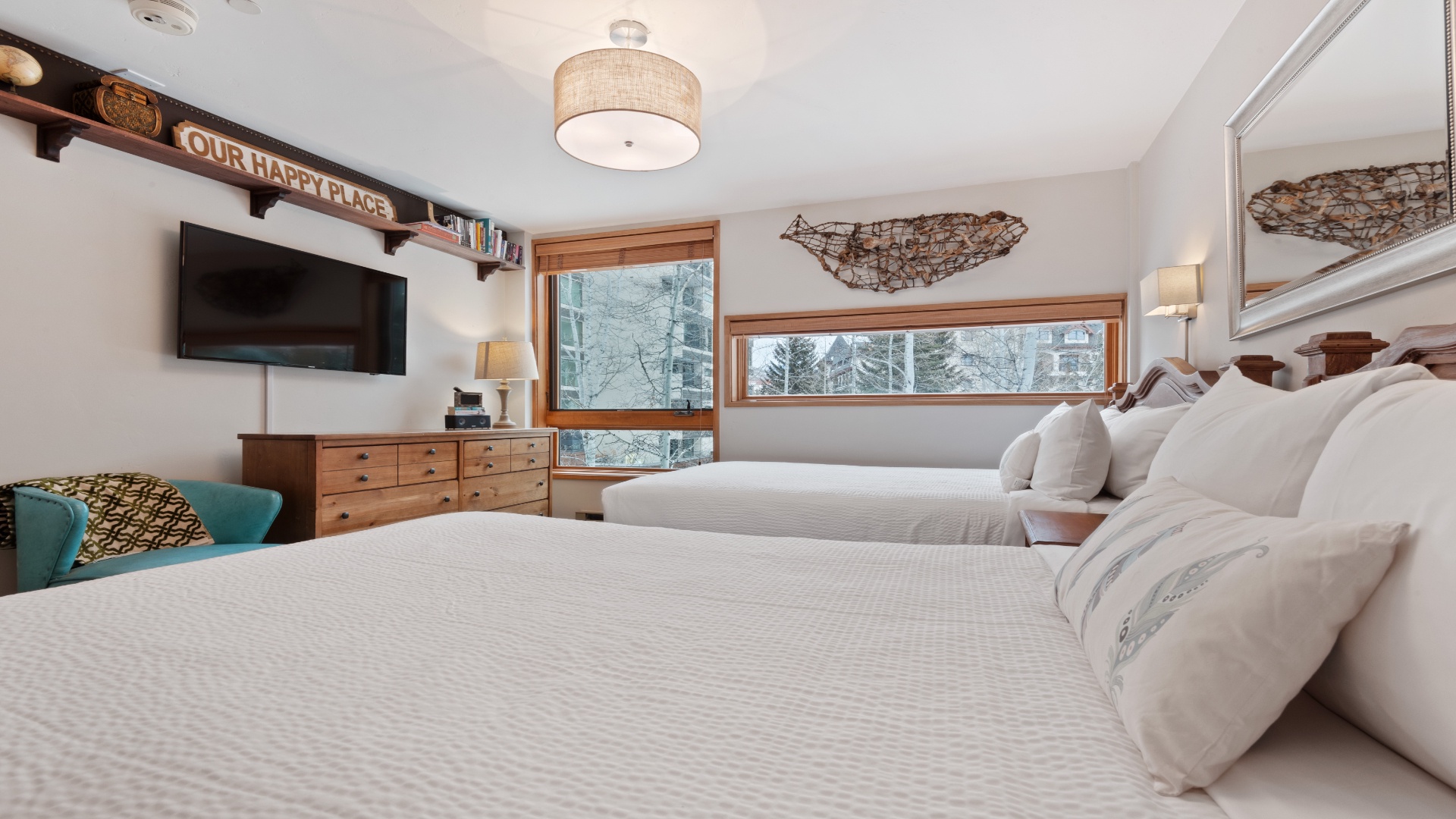 Sink into crisp linens and wake up to snowy mountain views through panoramic windows. Your cozy retreat features two beds, warm wood furnishings, and thoughtful touches that make this your happy place.