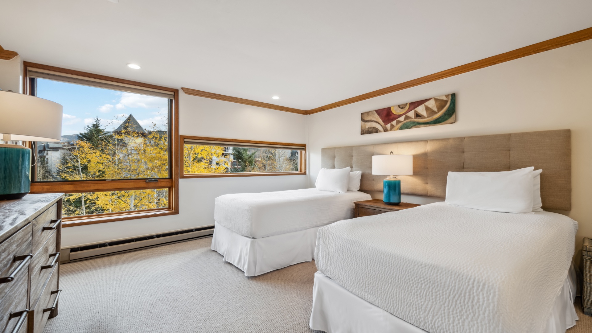 Wake up to crisp mountain air and golden aspens framing your window. Two plush beds, modern decor, and serene tones create your cozy alpine retreat.
