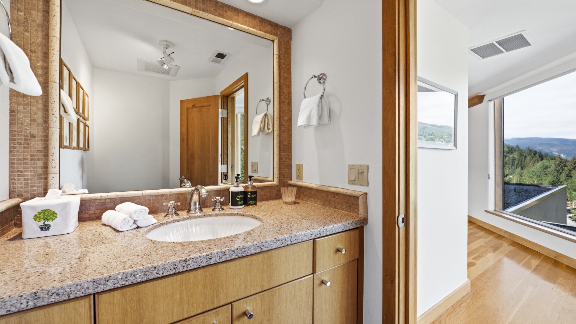 Step into your private sanctuary, where the granite vanity and warm wood tones welcome you after a day of adventure. Fresh towels await, while mountain views beyond remind you of the peaceful retreat you've found.