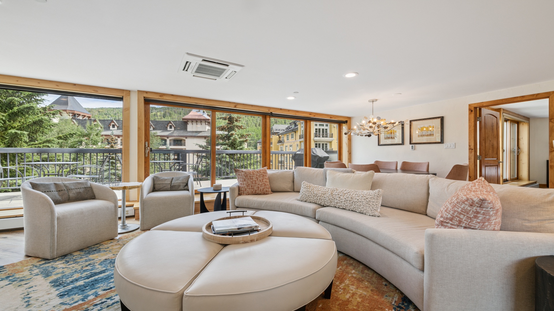 Settle into your spacious living area where modern mountain elegance meets comfort. Floor-to-ceiling windows frame village views, inviting natural light to fill your retreat.