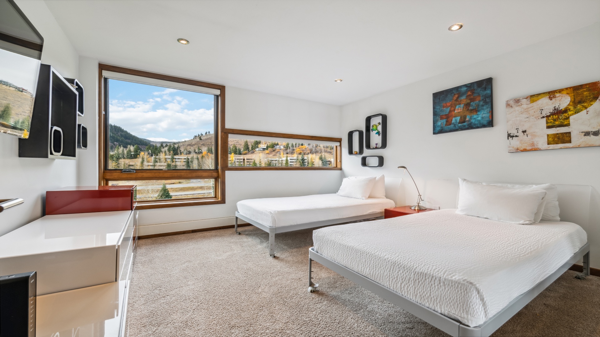 Wake up to stunning mountain and village views framed by large windows, inviting natural light into your serene twin bedroom retreat.