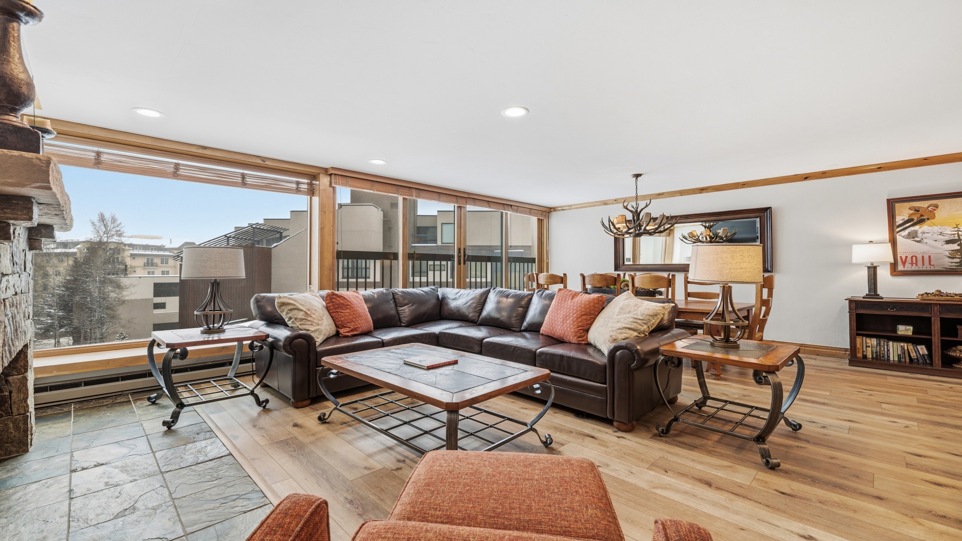 Relax in this spacious, sunlit living area with plush leather seating, stunning mountain views, and rustic touches that create your perfect alpine retreat.