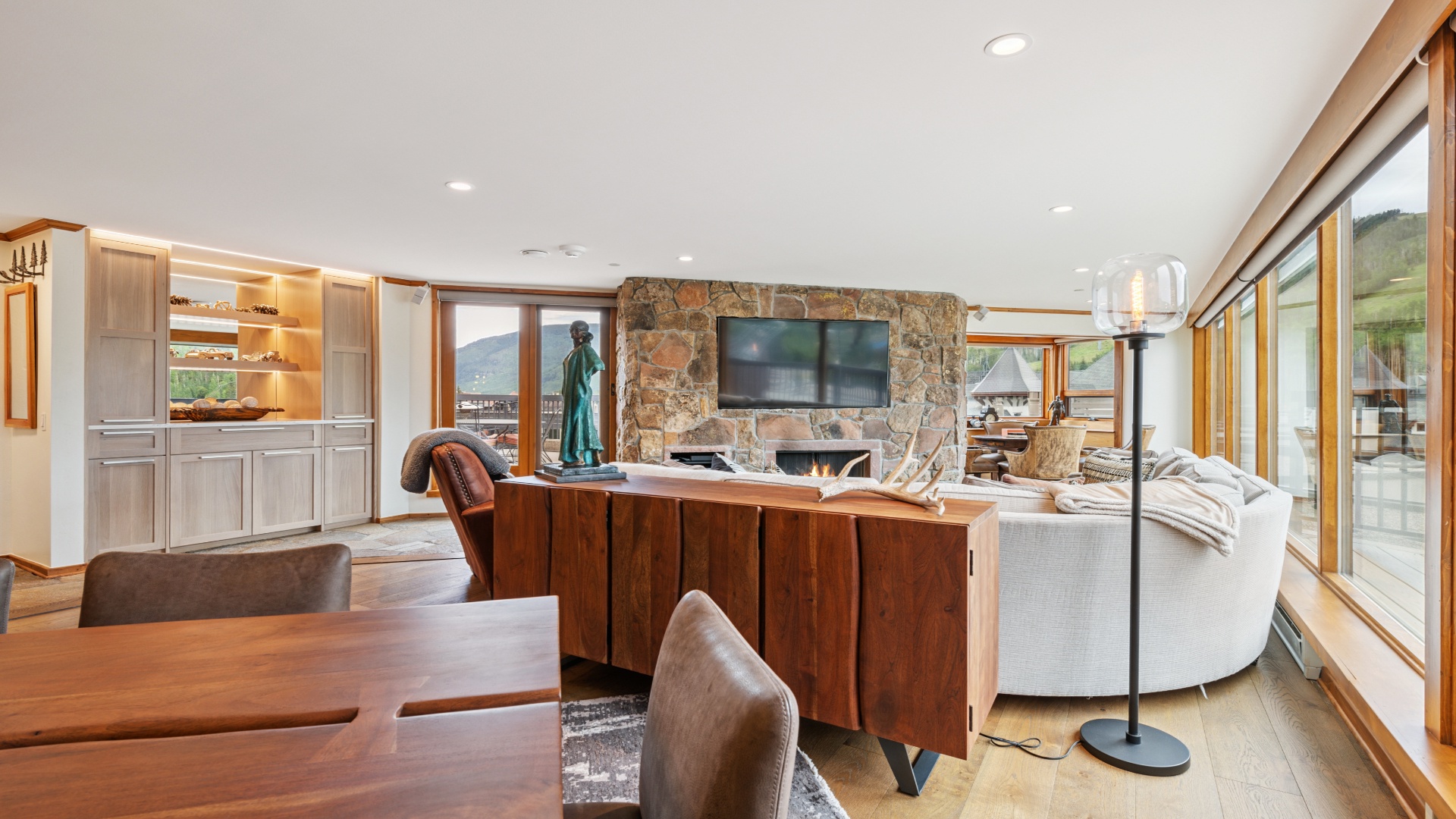 Relax in your open-concept living space with stone fireplace, mountain views, and elegant wood accents—designed for memorable moments with loved ones.