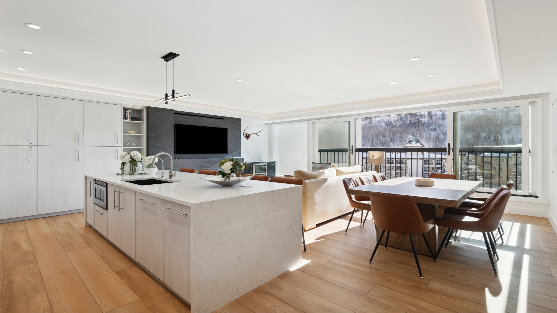 Modern open-concept living with sleek finishes and natural light. Your spacious kitchen island flows into a cozy dining area, perfect for gathering with loved ones while enjoying mountain views through floor-to-ceiling windows.