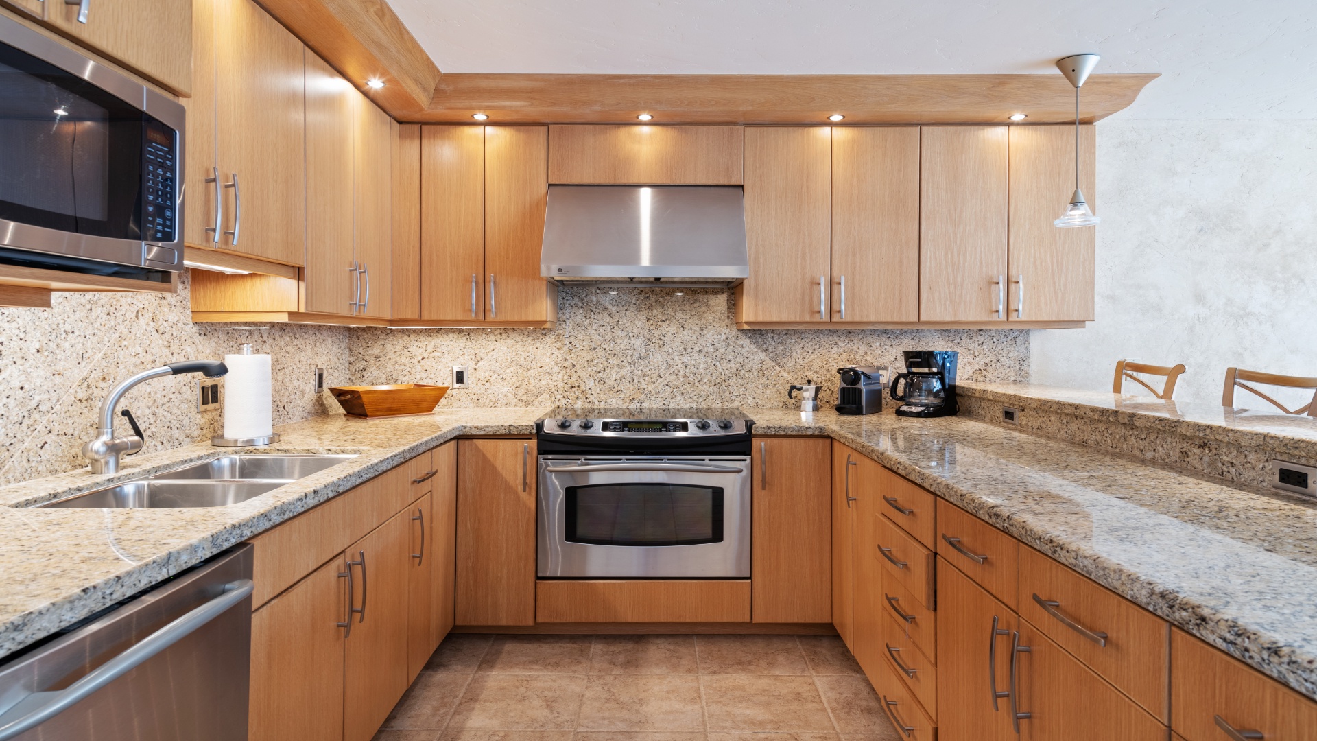 Your fully equipped kitchen awaits with sleek granite countertops, stainless steel appliances, and warm wood cabinetry—perfect for preparing home-cooked meals during your stay.