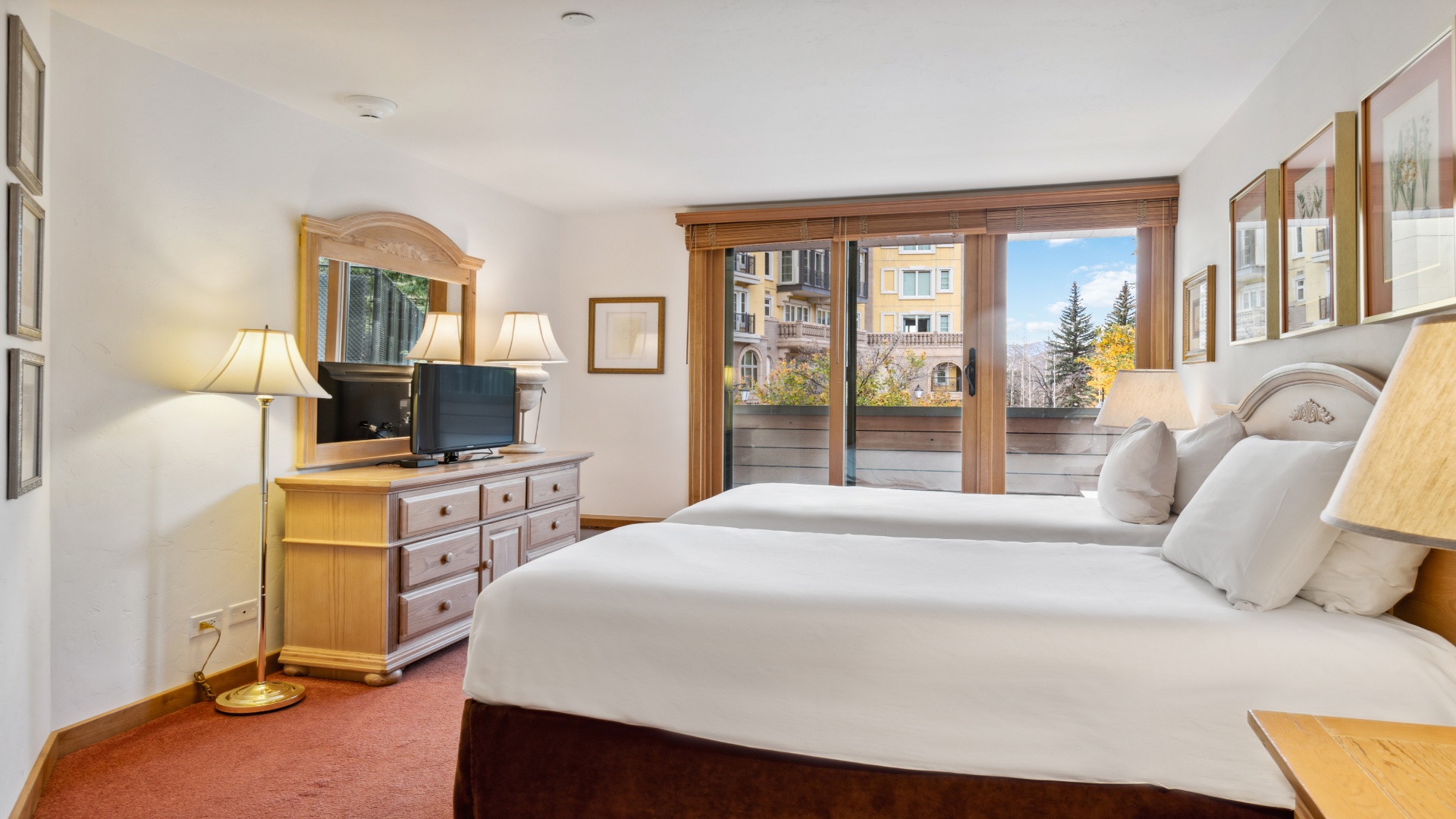 Your mountain retreat awaits with two plush beds, warm wood furnishings, and a private balcony overlooking scenic mountain vistas—perfect for unwinding after a day of adventure.